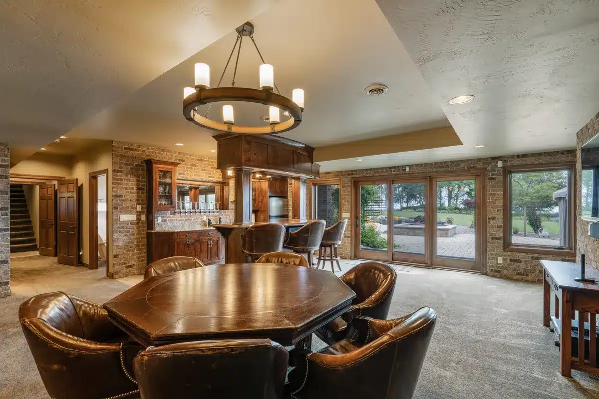 Downstairs game area at Mansion on the Lake with view of patio doors leading to outdoor pool, hot tub, and Lake Michigan